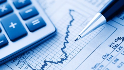 Close-up of a Calculator and Pen on a Financial Newspaper.  Blue-toned.